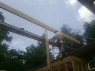 Carpenter setting a ridge beam over a new addition frame — Ice Dam Removal by Roofing Brothers in Vancleave